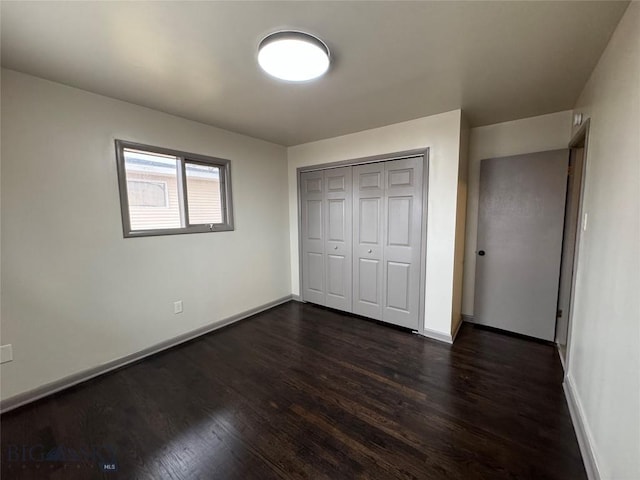 unfurnished bedroom with a closet and dark hardwood / wood-style floors