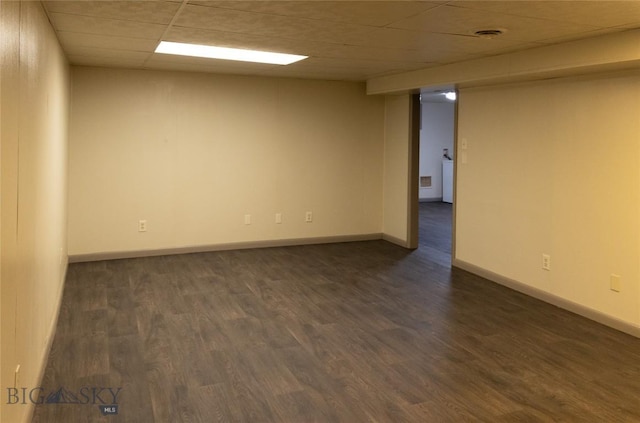 empty room featuring dark hardwood / wood-style floors and a drop ceiling