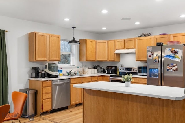 kitchen with light wood-type flooring, stainless steel appliances, sink, pendant lighting, and light brown cabinets