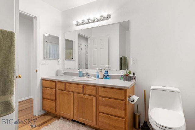 bathroom featuring hardwood / wood-style floors, vanity, and toilet