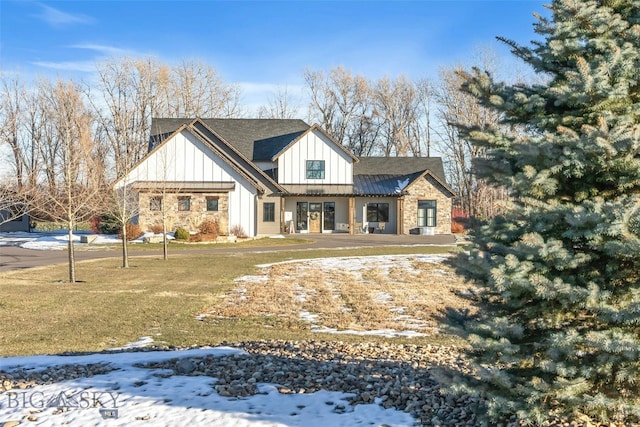 4807 Jordan Spur Rd, Bozeman, MT 59715 - modern farmhouse style home featuring board and batten siding, a yard, a standing seam roof, and stone siding