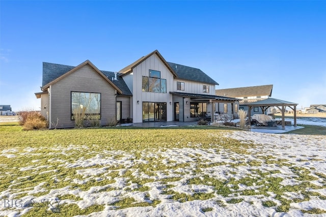 snow covered back of property featuring a gazebo, a patio area, and a yard