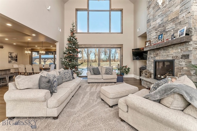 living room with hardwood / wood-style floors, a towering ceiling, and a wealth of natural light