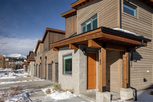 snow covered property with a garage