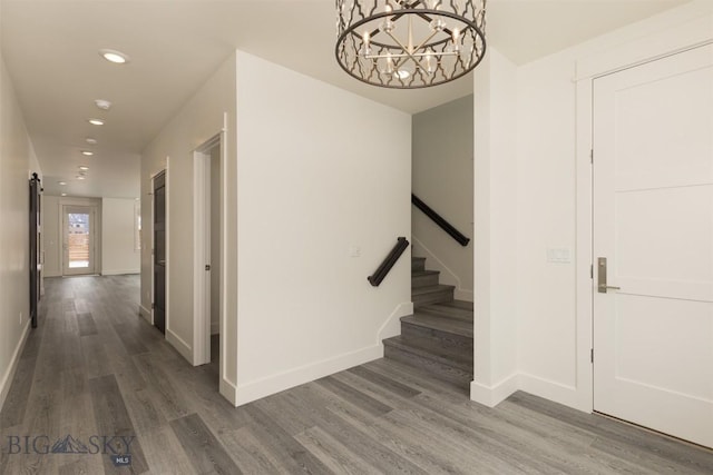 hall with dark hardwood / wood-style floors and a notable chandelier