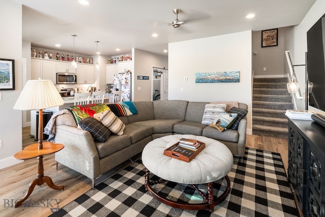 living room featuring light hardwood / wood-style flooring and ceiling fan