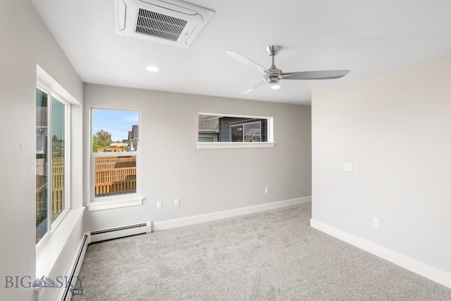 carpeted empty room featuring ceiling fan and a baseboard heating unit