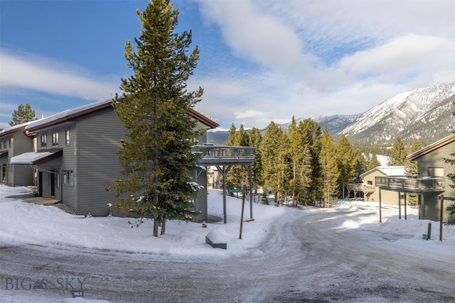 snow covered property featuring a deck with mountain view