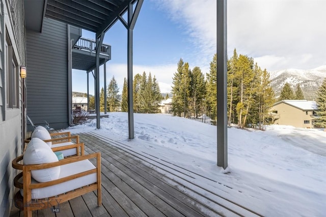 snow covered deck featuring a mountain view