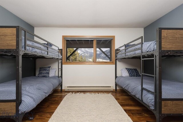 bedroom featuring dark hardwood / wood-style floors and a baseboard heating unit