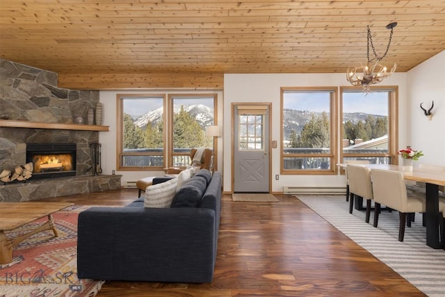 living room featuring a healthy amount of sunlight, a stone fireplace, and wooden ceiling