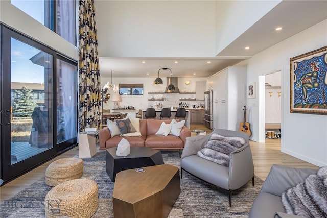 living room with a high ceiling and light wood-type flooring