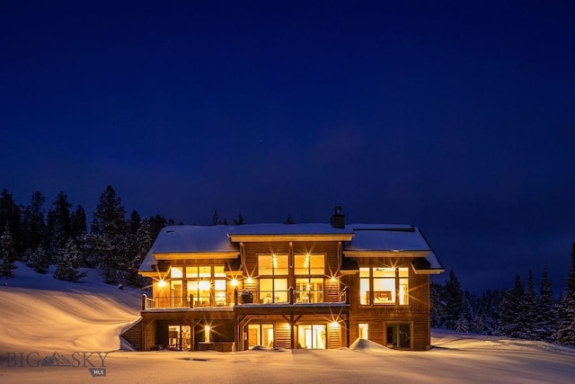 13 Middle Rider, Big Sky, MT 59716 - snow covered rear of property featuring a balcony and a chimney