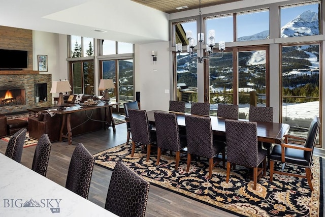 13 Middle Rider, Big Sky, MT 59716 - dining area featuring wood finished floors, a fireplace, healthy amount of natural light, a chandelier, and a high ceiling