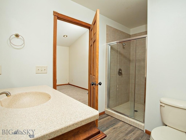 bathroom with hardwood / wood-style flooring, toilet, an enclosed shower, and sink