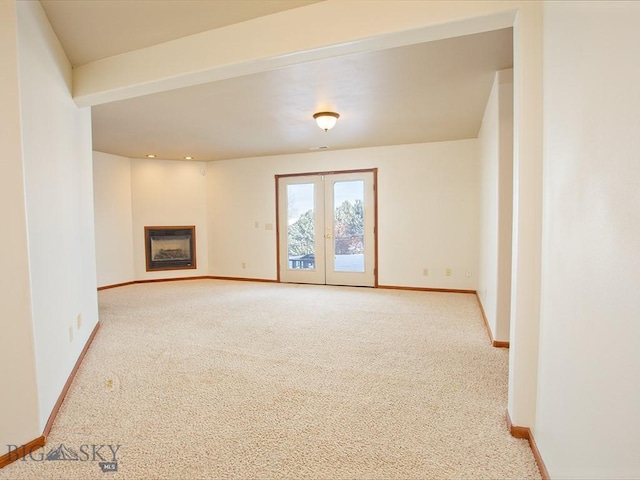 unfurnished living room featuring light carpet and french doors