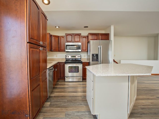 kitchen featuring stainless steel appliances, a kitchen island, dark hardwood / wood-style floors, and light stone counters