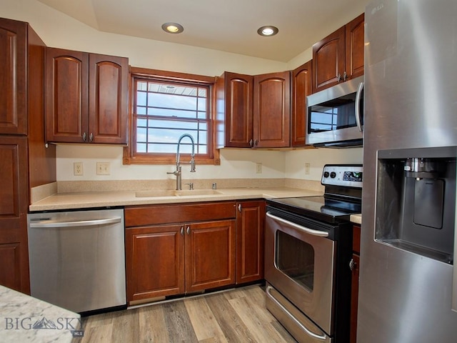 kitchen featuring stainless steel appliances, light hardwood / wood-style flooring, and sink