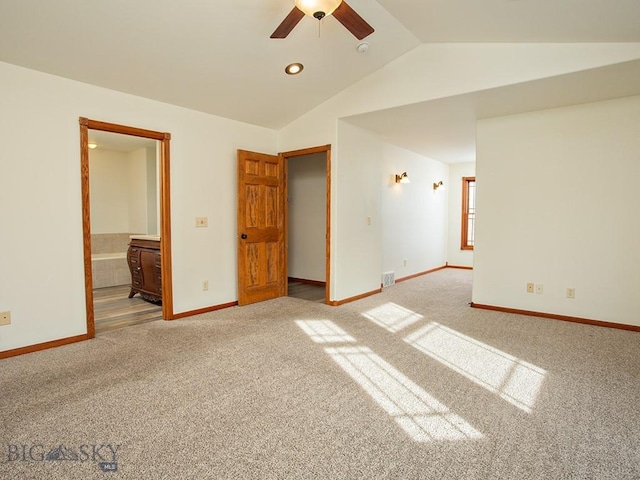 carpeted spare room with ceiling fan and vaulted ceiling