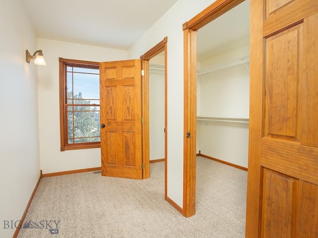 hallway featuring light colored carpet