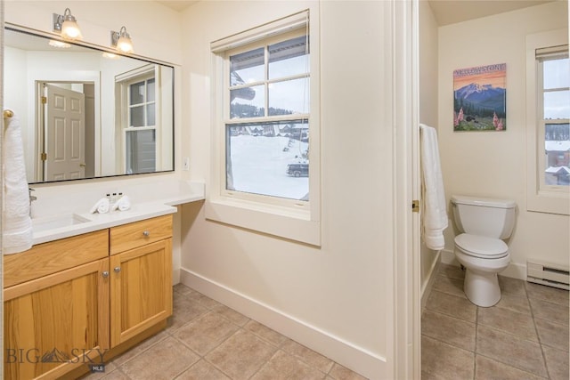 bathroom featuring toilet, vanity, tile patterned floors, and baseboard heating