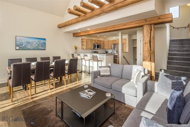 living room with a towering ceiling and dark wood-type flooring