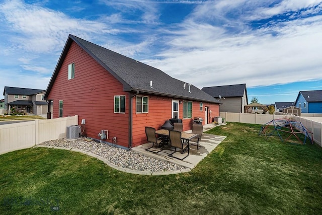 rear view of property with a patio area, central air condition unit, and a lawn