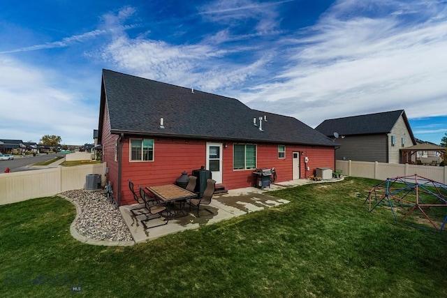 rear view of house featuring a yard, cooling unit, and a patio area