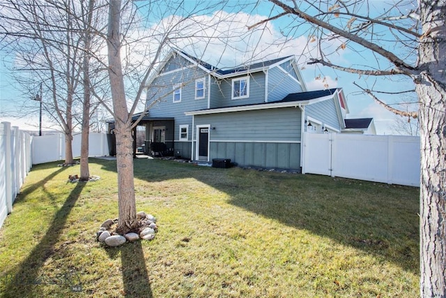 back of house featuring a lawn