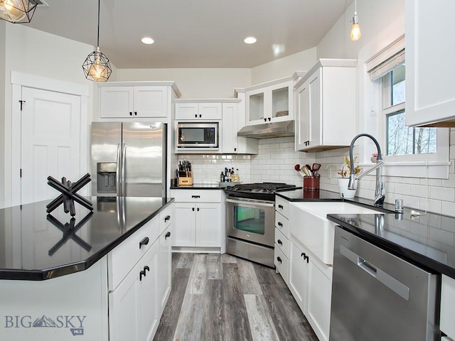 kitchen featuring sink, white cabinetry, appliances with stainless steel finishes, dark hardwood / wood-style flooring, and pendant lighting