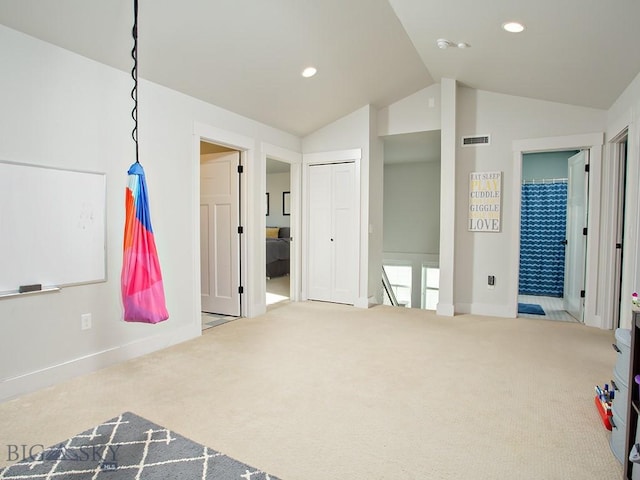 carpeted bedroom featuring lofted ceiling and connected bathroom