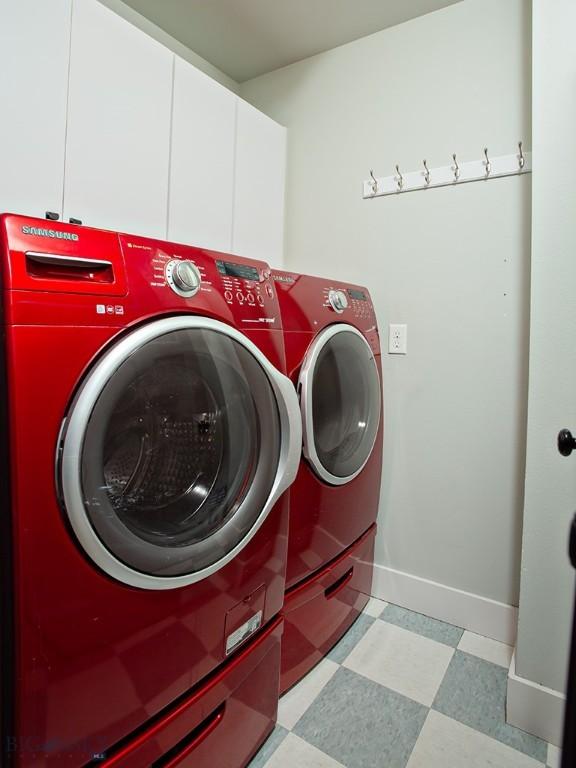 washroom featuring washing machine and dryer and cabinets