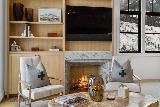 sitting room featuring a high end fireplace and built in shelves