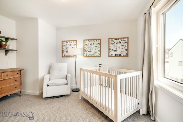 carpeted bedroom featuring a crib and multiple windows