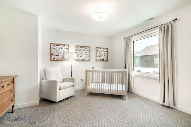 bedroom featuring a nursery area and carpet