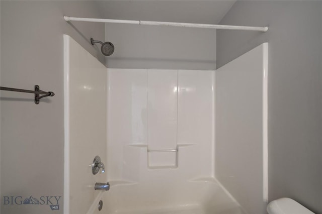 bathroom with bathtub / shower combination and toilet