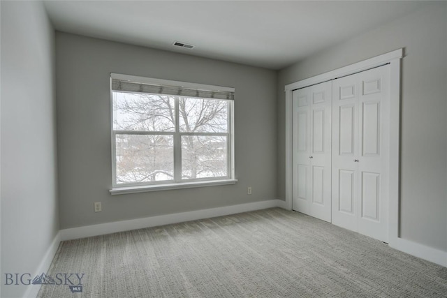 unfurnished bedroom featuring carpet flooring and a closet