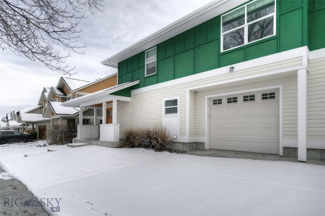 view of snow covered exterior with a garage