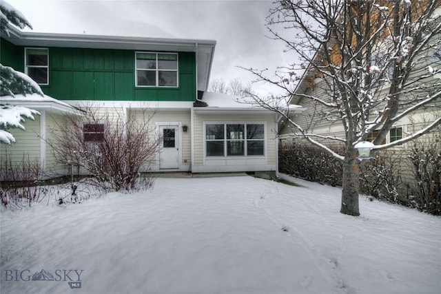 view of snow covered back of property