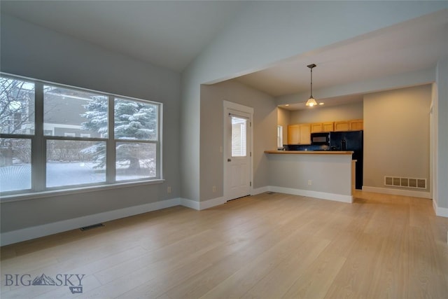 unfurnished living room featuring light hardwood / wood-style flooring and lofted ceiling