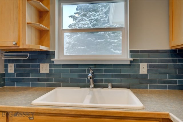 room details featuring light brown cabinets, sink, and tasteful backsplash