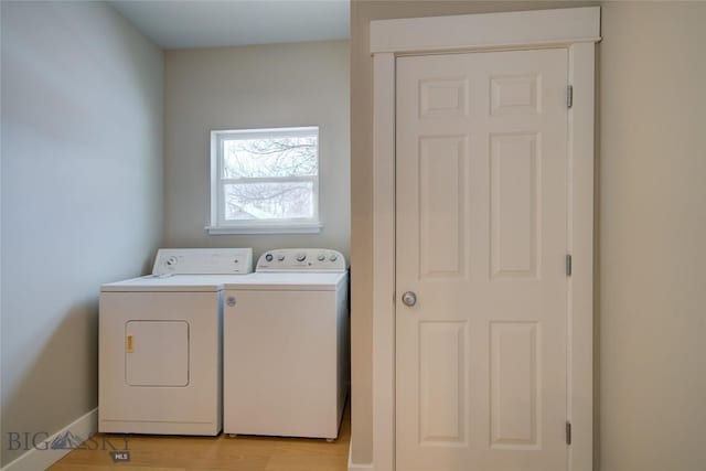 laundry area featuring separate washer and dryer and light hardwood / wood-style flooring