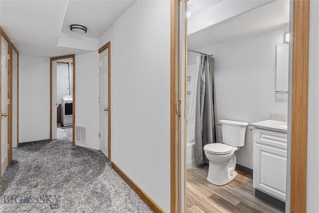 full bathroom featuring washer / clothes dryer, vanity, shower / tub combo, and toilet