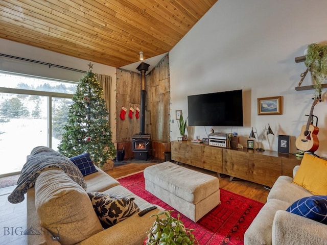 living room featuring a wood stove, hardwood / wood-style floors, high vaulted ceiling, and wood ceiling