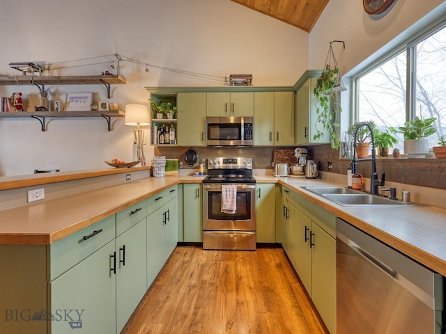 kitchen featuring stainless steel appliances, green cabinets, sink, light hardwood / wood-style flooring, and lofted ceiling