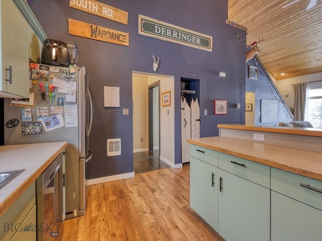 kitchen with stainless steel fridge, light hardwood / wood-style floors, and wooden ceiling