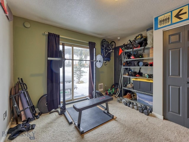 exercise area featuring carpet and a textured ceiling