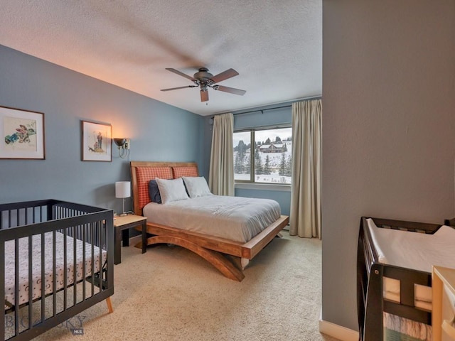 carpeted bedroom with a textured ceiling and ceiling fan