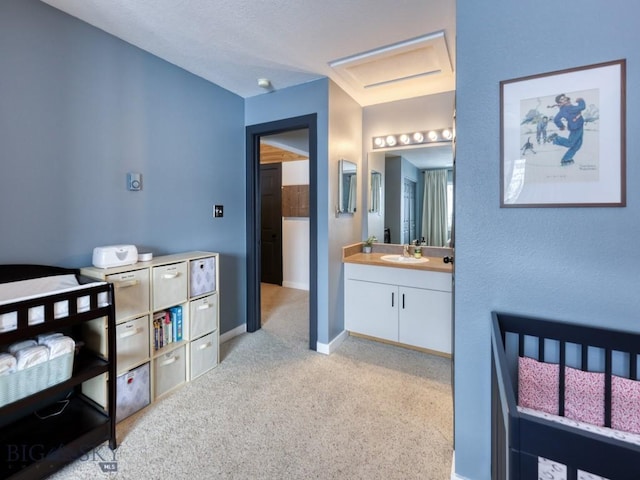 carpeted bedroom featuring ensuite bathroom and sink