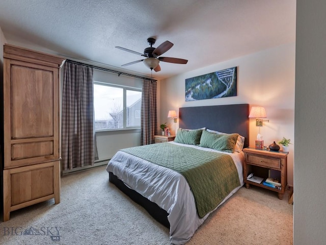 bedroom featuring ceiling fan, light colored carpet, a textured ceiling, and a baseboard radiator